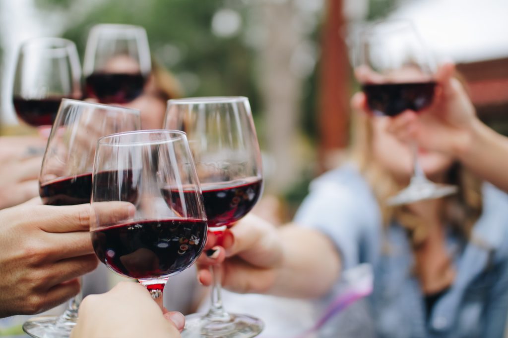 Group of friends cheering with glasses of red south african wine